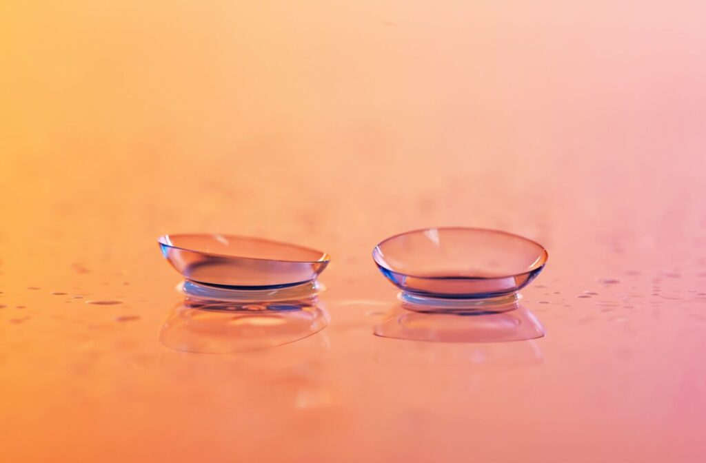 A pair of contact lenses sits on a glass surface.